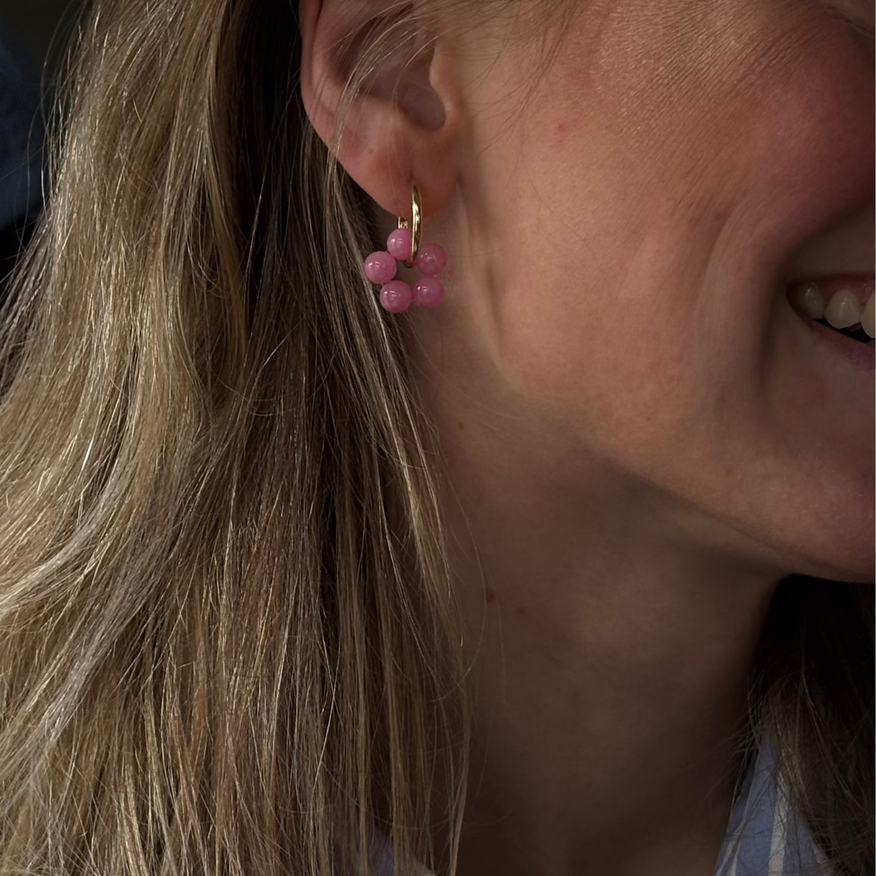 Tragebild von goldenen Kreolen mit pinker Perlenblume